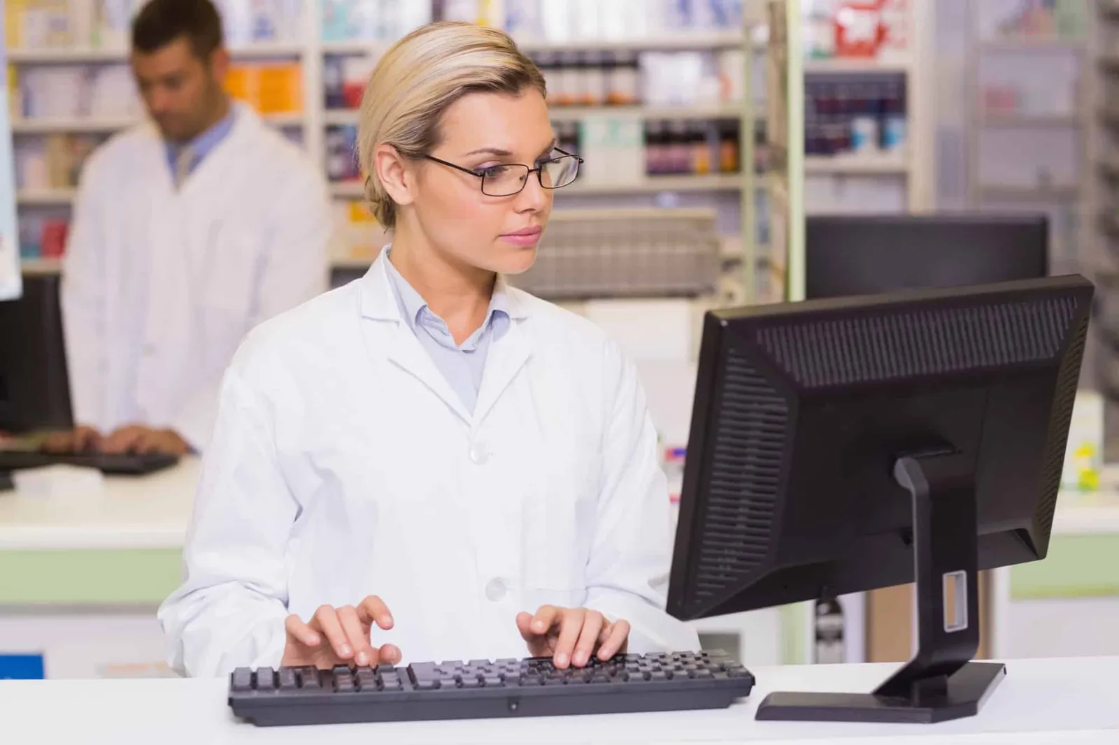 Pharmacist entering a prescription claim at a pharmacy workstation